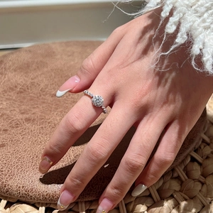 Primo piano di un anello in argento sterling S925 con halo di moissanite scintillante