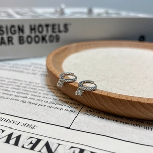 S925 sterling silver hoop earrings with a dangling moissanite pendant on a display tray
