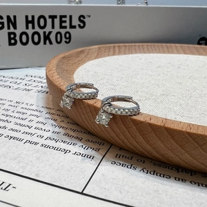 Detail of S925 sterling silver hoop earrings with a sparkling Moissanite pendant