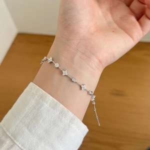 Exquisite S925 sterling silver bracelet with clover and round charms on wrist