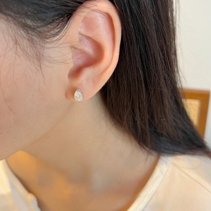 Close-up of S925 silver pear-cut moissanite stud earring worn by a model for a bridal look