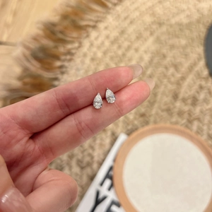Macro detail of pear-cut moissanite earrings in S925 sterling silver prong setting