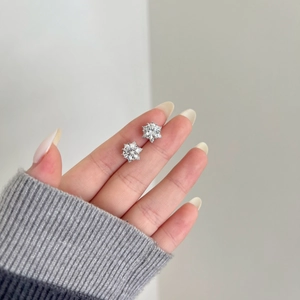 Detailed close-up of S925 sterling silver snowflake earrings with sparkling moissanite stones