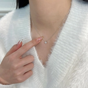 Gros plan du collier en argent S925 avec pendentif trèfle scintillant sur modèle