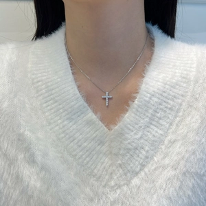Minimalist S925 silver cross necklace with sparkling stones on a model wearing white sweater