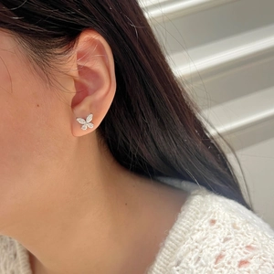Close-up of a silver butterfly stud earring with shimmering micro-paved marquise moissanite