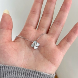 Gros plan du pendentif trèfle en argent S925 avec nacre blanche et zircon scintillant