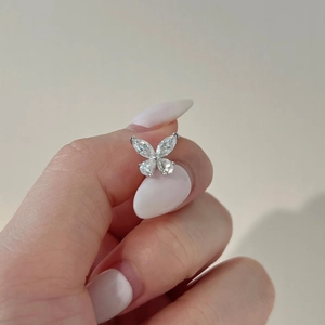 Macro shot of S925 sterling silver marquise butterfly moissanite stud earrings on fingers
