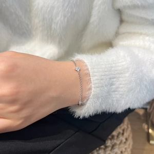 Macro detail of S925 sterling silver clover bracelet with sparkling moissanite diamonds