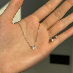 Close-up of S925 sterling silver jewelry set with bezel-set round solitaires on palm