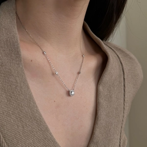 Detail of S925 silver square pendant necklace with halo crystals on a female model