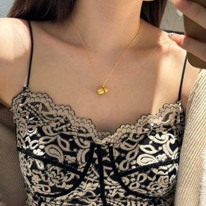 Close-up of golden S925 sterling silver necklace with double ball pendant on neck
