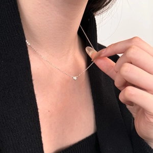 Close-up of minimalist S925 sterling silver solitaire necklace on female model