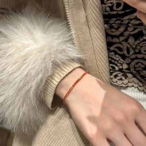 Gros plan d'un bracelet en argent S925 plaqué or avec zircon rouge sur un poignet féminin