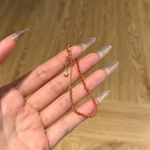 Détail du bracelet tressé rouge avec chaîne en argent S925 et breloque en cristal brillant