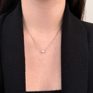 Detail of elegant S925 sterling silver necklace with round bezel-set moissanite pendant