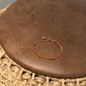 Bracelet tressé en cordon rouge et chaîne dorée avec fermoir réglable sur cuir
