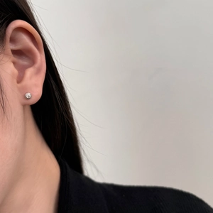 Close-up of S925 sterling silver bezel set stud earring worn on earlobe for business style
