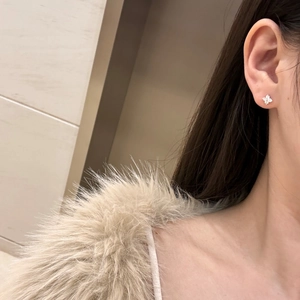 Detailed view of silver S925 four-leaf flower stud earrings with shimmering zircons