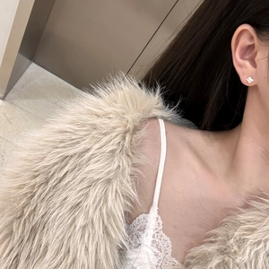 Close-up of S925 sterling silver star-shaped stud earring worn by a model in soft lighting
