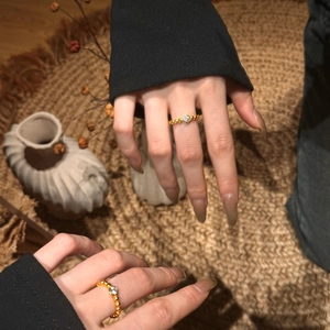 Détail macro de la bague en argent S925 perlée dorée avec pierre claire sur les mains