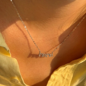 Detalle del collar MAMA de plata de ley S925 con microcristales en el cuello femenino