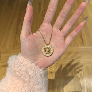 Vue détaillée du pendentif roulette doré orné avec des pierres de zircone blanches