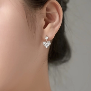Close-up of S925 sterling silver heart-shaped gemstone earrings on a model's ear