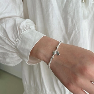 S925 sterling silver beaded bracelet featuring smile and fish charms on model wrist