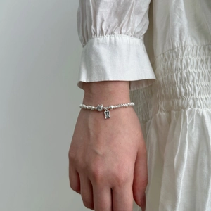 Close-up of S925 sterling silver cat bracelet with smile fish charm on model wrist