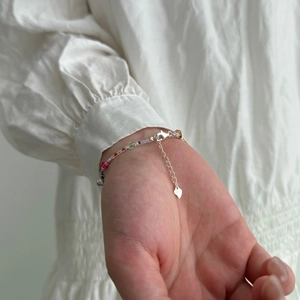 Colorful gemstone glass bead bracelet with S925 sterling silver heart charm on wrist