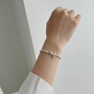 Close-up of S925 silver beaded bracelet featuring a cat and smile fish charm on wrist