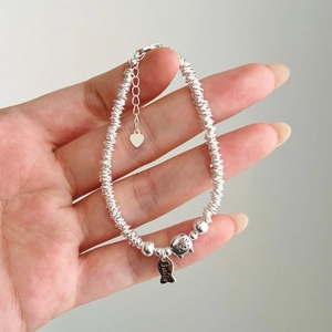 Hand holding S925 sterling silver beaded bracelet with cat and fish smile charms