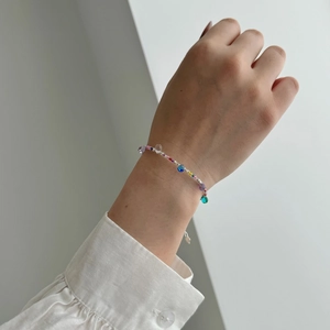 Detail of S925 sterling silver bracelet featuring colorful beads on a woman's wrist