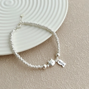 Detail shot of S925 sterling silver kitten bracelet with engraved Smile fish pendant