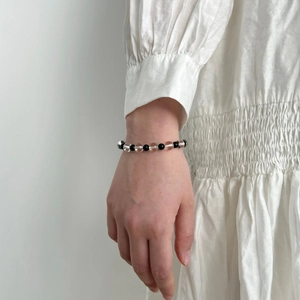 Detail of beaded bracelet with black onyx and clear crystal on a model's wrist