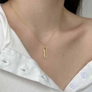 Détail du collier MAMA doré avec pierres de zircon sur le cou d'un mannequin pour la fête