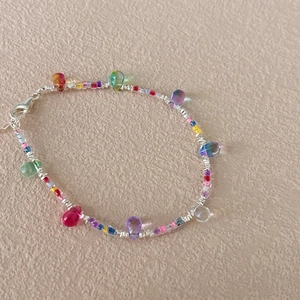 Close-up of bohemian silver bracelet with colorful teardrop beads and lobster clasp