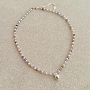 Détail du collier de perles en pierres naturelles violettes avec pendentif en argent