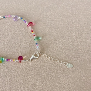 Close-up of S925 sterling silver bracelet with colorful water drop beads and heart tag