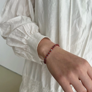 Detail of S925 silver bracelet with natural red agate and apatite beads on a wrist