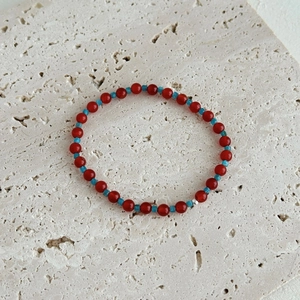 S925 silver bracelet with red agate and apatite beads on a natural stone surface