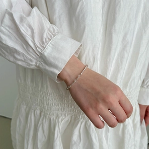 Detail of minimalist S925 sterling silver bracelet with strawberry crystal and clear beads