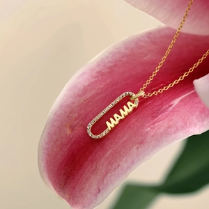 Détail du collier MAMA doré avec diamants pavés sur des pétales de lys roses