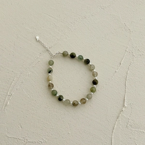 Macro detail of S925 sterling silver clasp and natural green rutilated quartz gemstone beads