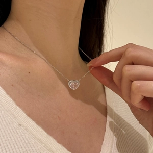Detail of pink heart-shaped pendant necklace in S925 silver worn by a model