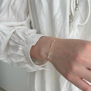 Close-up of minimalist S925 sterling silver chain bracelet on model's wrist