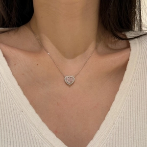 Close-up of heart-shaped pink zircon pendant necklace with a pavé halo on a female model