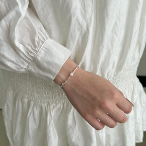 Detail of S925 sterling silver butterfly floral bracelet worn on a woman's wrist