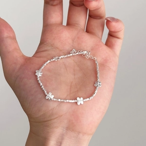 Handheld view of S925 sterling silver butterfly bracelet with dainty silver beads and lobster clasp
